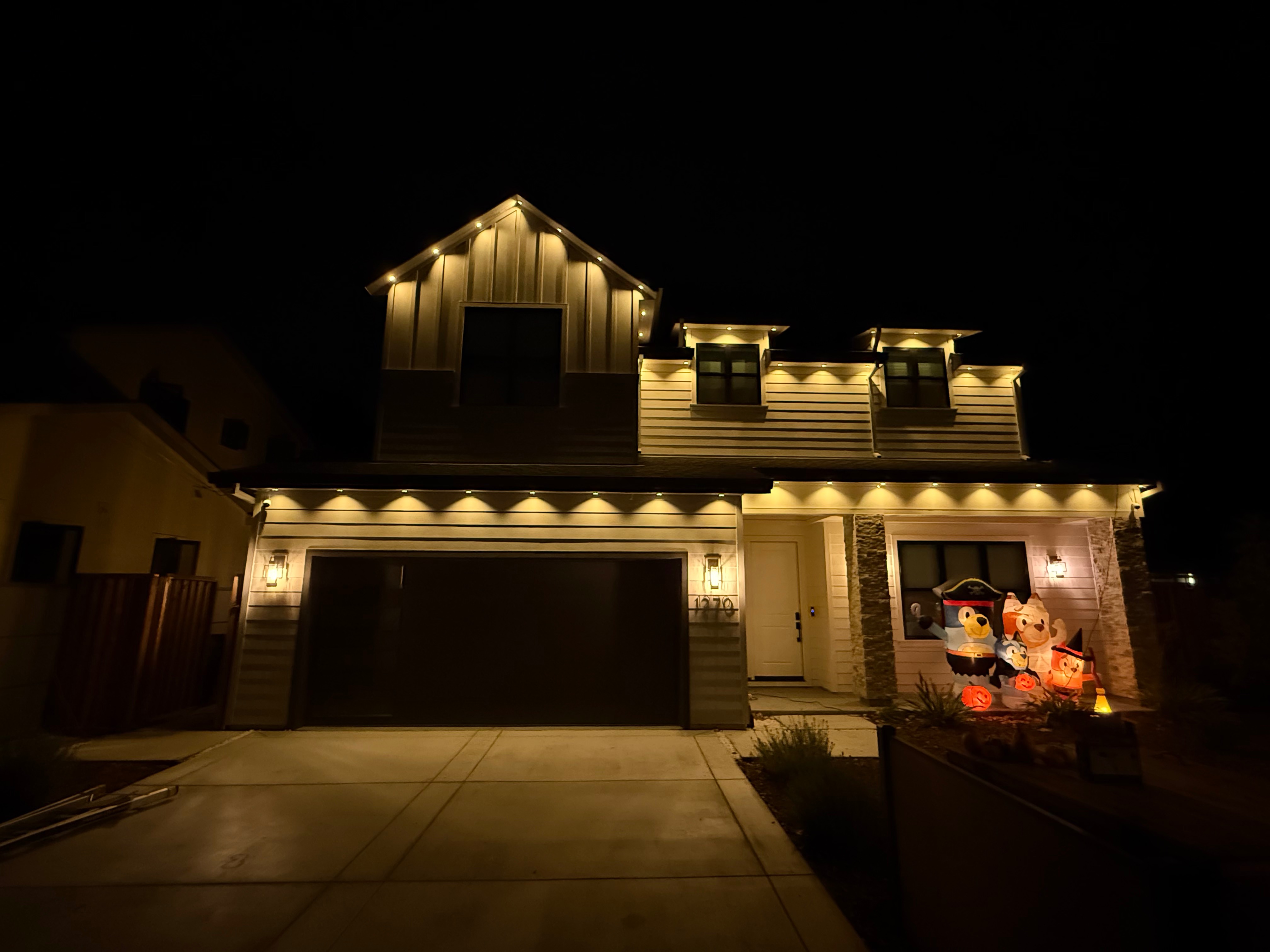 Warm white permanent exterior Christmas lighting with Halloween decorations