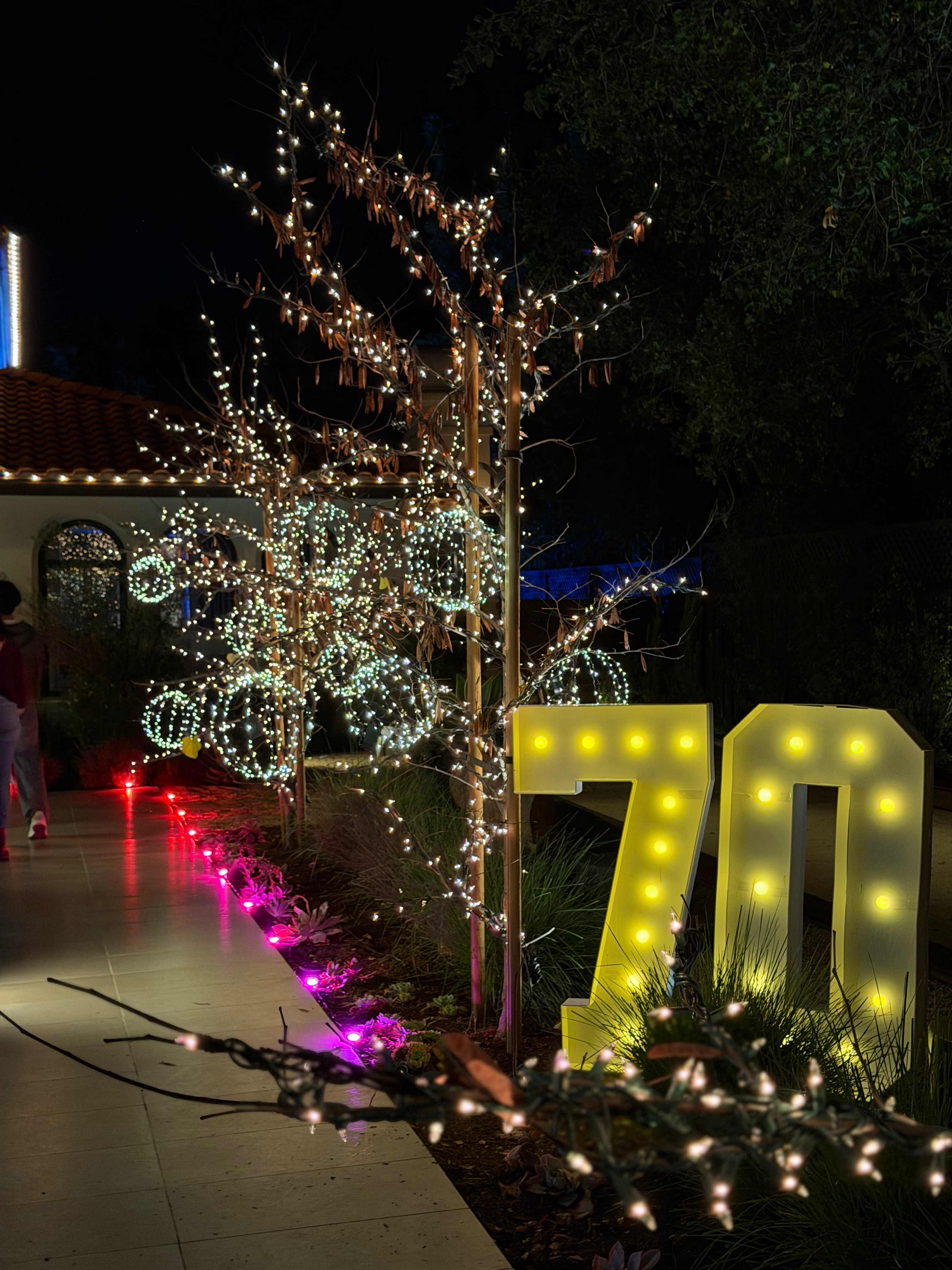 70th birthday celebration with tree lighting and marquee numbers